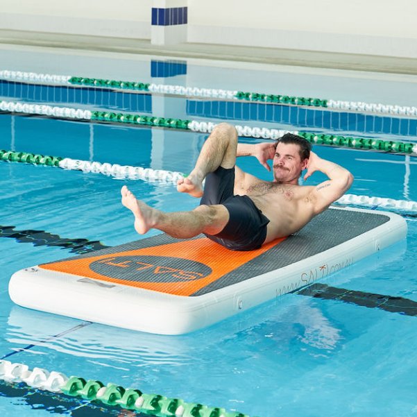 Man doing crunches on a Salti board in a pool